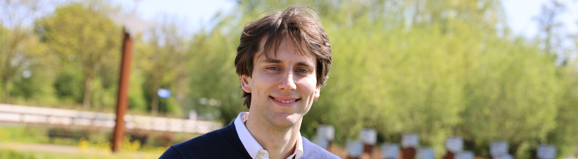 Jarno buiten lachend naar de camera in een groene omgeving.