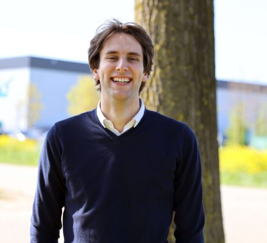 Portret van Jarno van voren. Buiten, lachend, in trui.