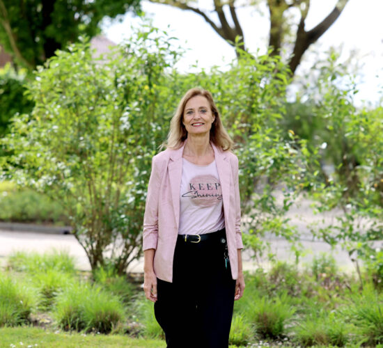 Jeanine Vonk buiten lopend in een groene omgeving.