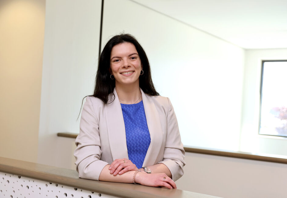 Simone leunend tegen balustrade bij raadszaal.