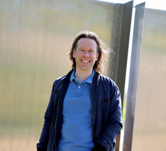 Steven buiten lachend voor het monument Keuze Vrijheid.